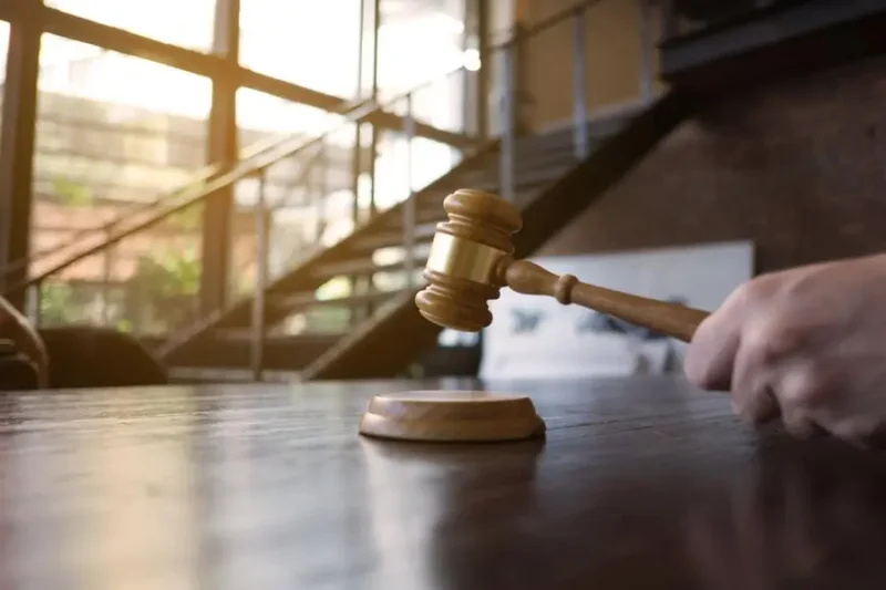 close-up-hand-holding-gavel-sounding-block-table_1048944-8971180